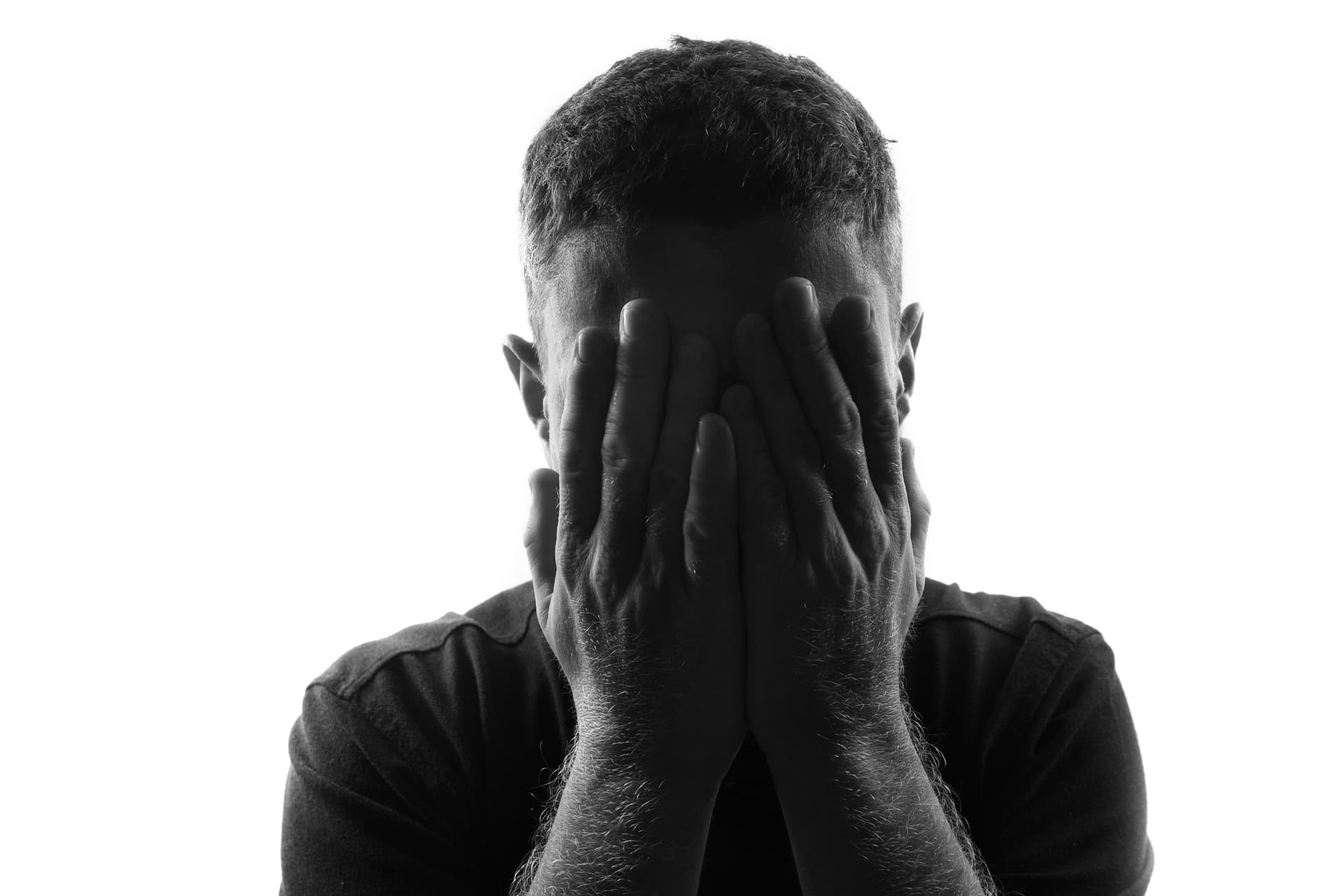 Person cringing with hands over face