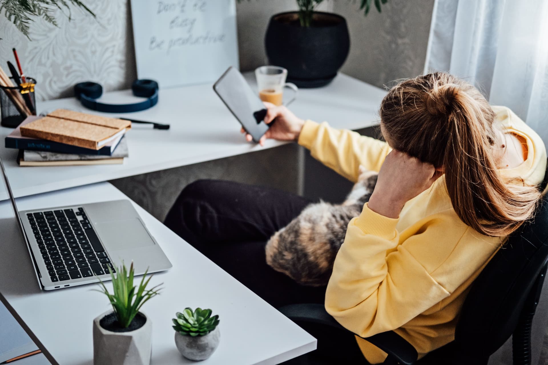Person distracted at desk looking away from computer