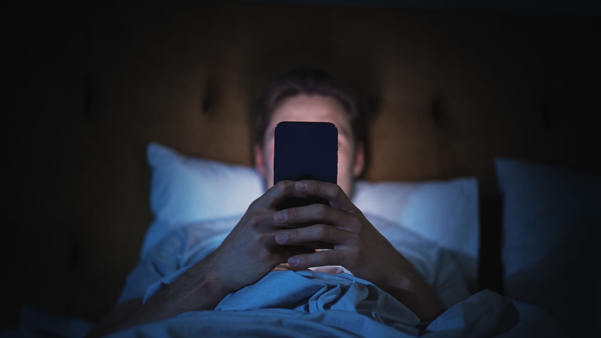 Person scrolling phone late at night